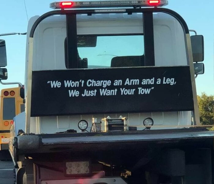 Baksidan av en bärgningsbil med texten "We Won't Charge an Arm and a Leg, We Just Want Your Tow".