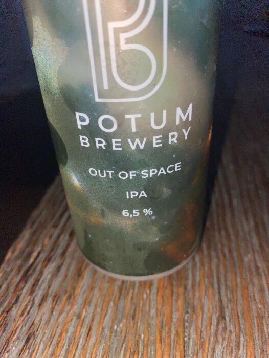 En burk IPA från Potum Brewery med 6,5 % alkoholhalt, märkt "Out of Space". Bakgrunden är en ojämn träyta.