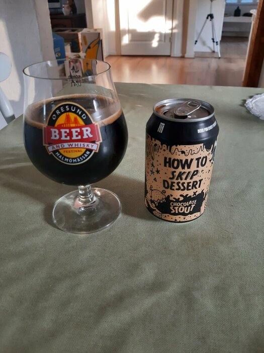 En ölburk märkt "How to Skip Dessert Chocolate Stout" och ett glas mörk stout på ett bord med grönt underlägg.