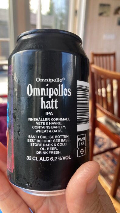 Svart burk med etikett för Omnipollo "Omnipollos hatt" IPA, 33 cl, 6,2% alkohol. Texten innehåller ingredienser, förvaringstips och bäst före-datum.