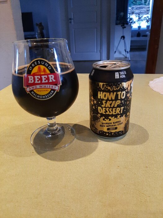 Ett glas med mörk öl från eventet "Öresund Beer and Whisky Festival" bredvid en burk med etiketten "How to Skip Dessert", en bourbonfatlagrad imperial stout.