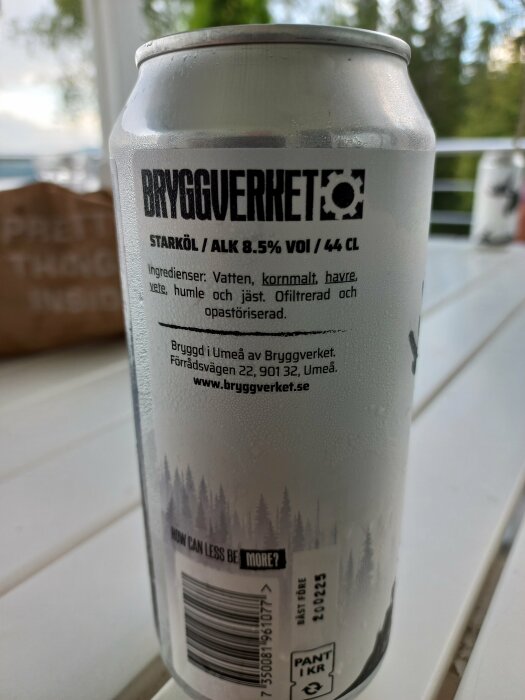 En burk starköl från Bryggverket med text som visar ingredienser och alkoholhalt, 8,5% och 44 cl, står på ett bord utomhus med träd i bakgrunden.