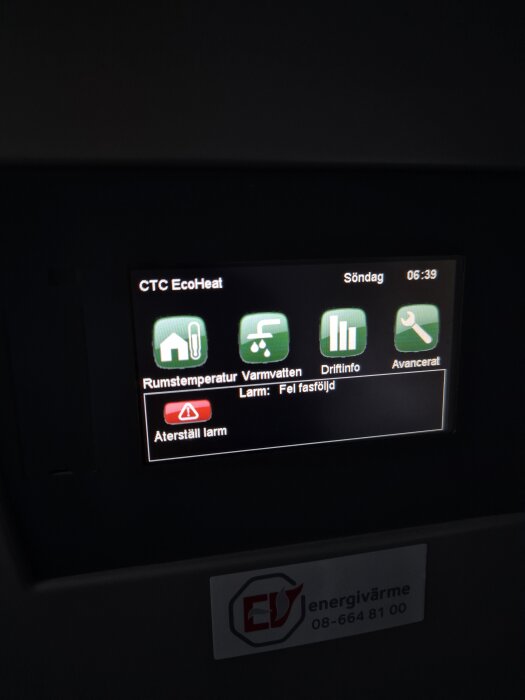Digital display på en CTC EcoHeat värmepump med meddelandet "Larm: Fel fasföljd" och en röd "Återställ larm" -knapp.