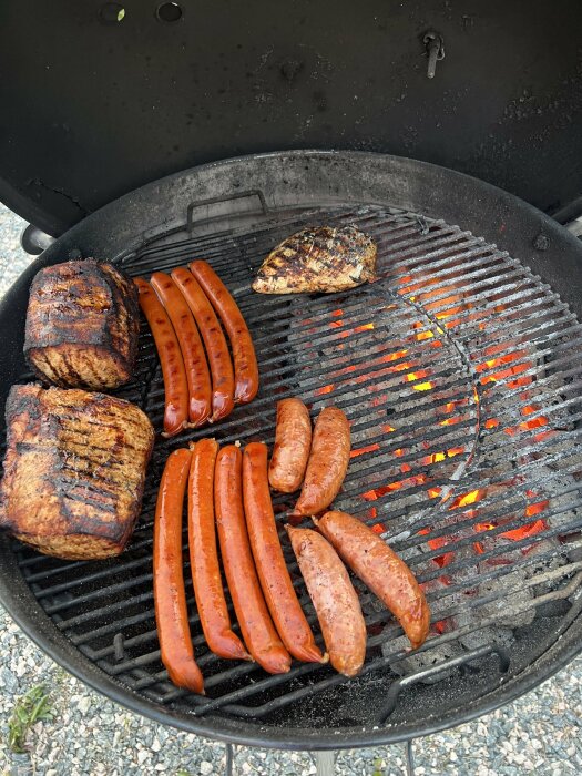 Grillning med korv, ytterfilé, kyckling och grillost på en kolgrill.