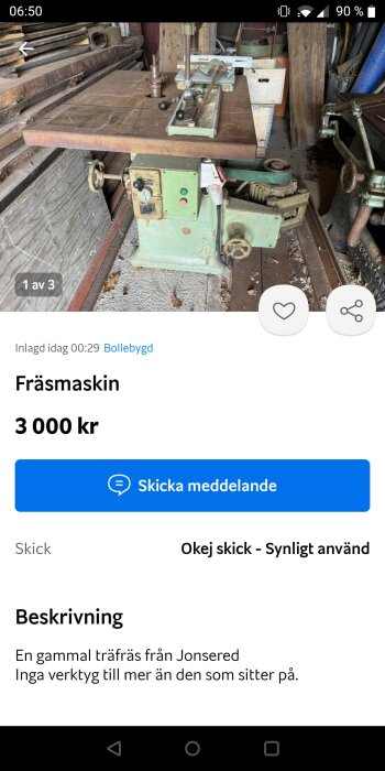 En äldre träfräs från Jonsered i ett gammalt skick, placerad i en verkstad omgiven av trä och metallföremål.