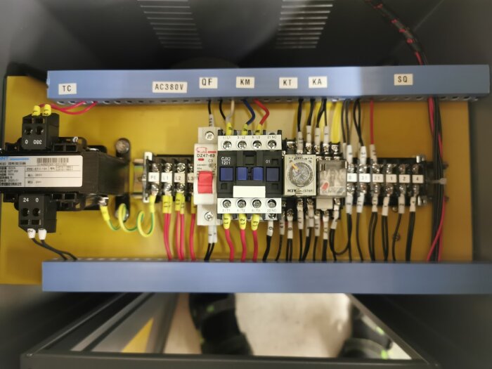 Manöverskåp med flera elkopplingar, ledningar och reläer inklusive ett KACX2-modul, M3Y timer och ett DZ47-63 brytare.