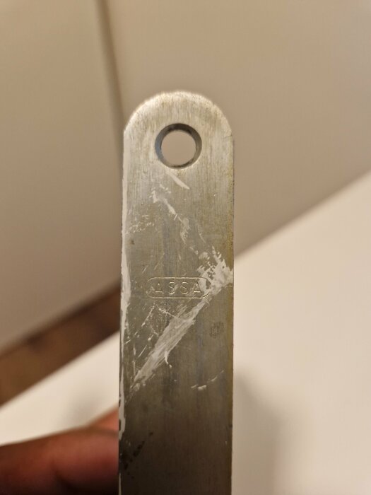 Närbild på en metallnyckel med en rund ögla i toppen och texten "ASSA" ingraverad, troligen för inomhusdörrar utan nycklar.