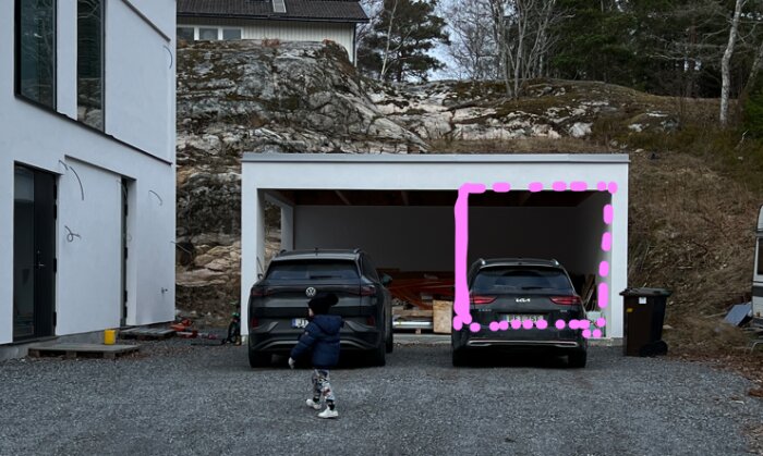 Bild på en carport med två parkerade bilar, en del av carporten till höger är markerad med rosa linje för att indikera platsen för ett planerat förrådsrum.