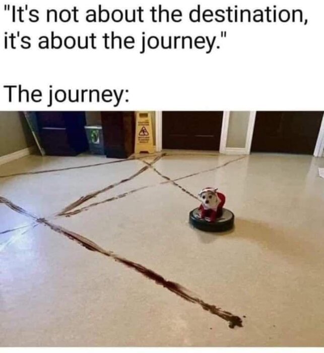 Bild med en text: "It's not about the destination, it's about the journey. The journey:" En robotdammsugare med en leksakshund lämnar smutsiga märken på golvet.