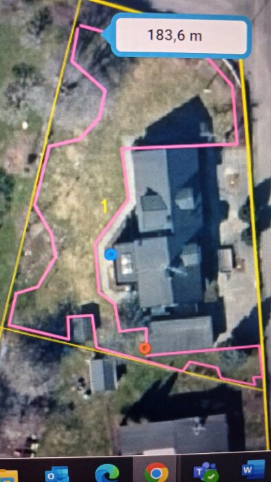 Flygbild över trädgård med markerade ytor för robotgräsklippare. Två punkter indikerar potentiella placeringar av laddstation (blå och röd plupp).