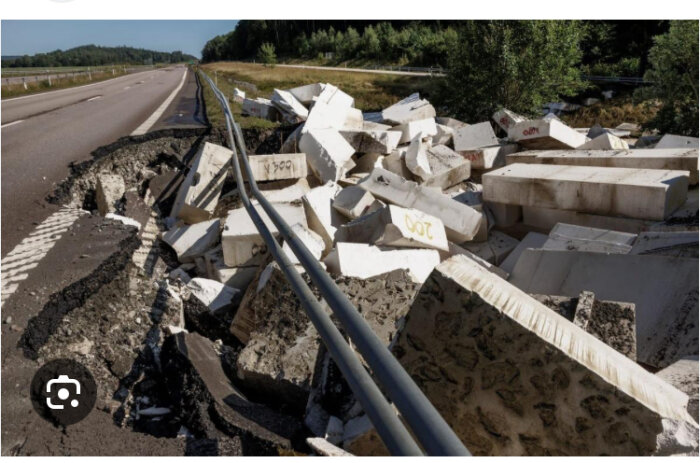 Rasat vägavsnitt vid Lilla Edet med en hög av betongblock och asfalt, avspärrat av vägräcken som böjt sig.