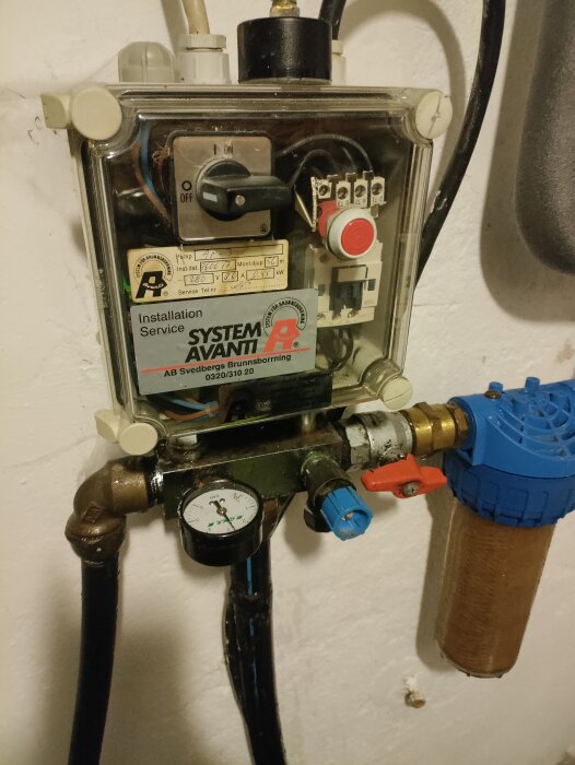 Närbild av en vattenpumpinstallation med en blå ventil som läcker. Pumpen är av märket System Avanti, installerad av Svedbergs Brunnsborrning.