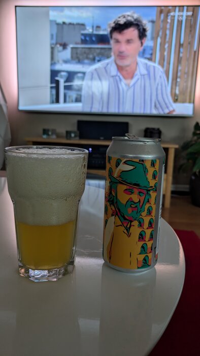 Burk och glas med öl från Nyköping Brewing på ett bord framför en tv.