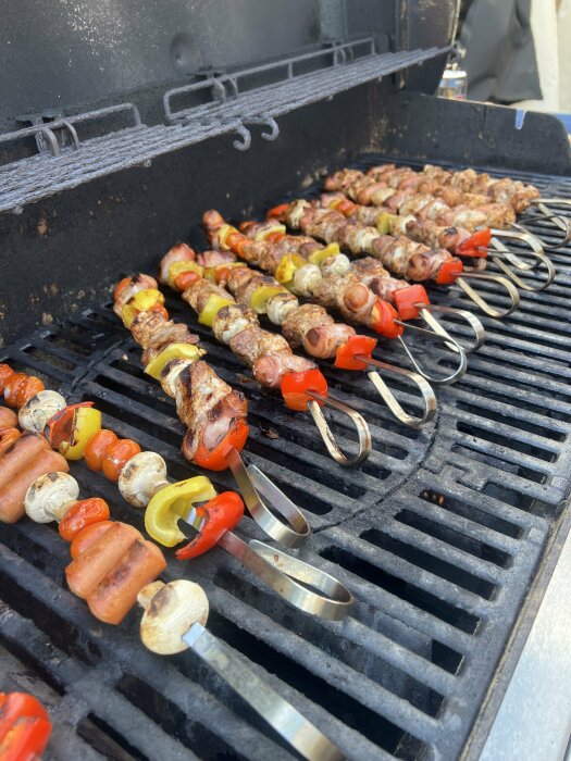 Grillspett med kött, paprika och svamp tillagas på en grill.