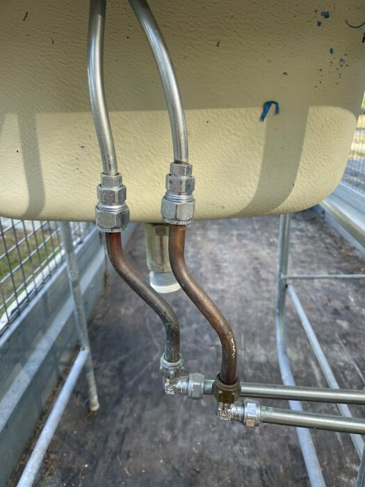 Två metallrör kopplade till anslutningar under en diskbänk, där frågan gäller övergång till R15 krankoppling.