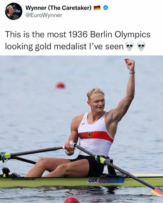 En man i tysk roddräkt sträcker armen i luften, sittande i en roddbåt på vattnet. Text ovan beskriver honom som en "1936 Berlin Olympics gold medalist.