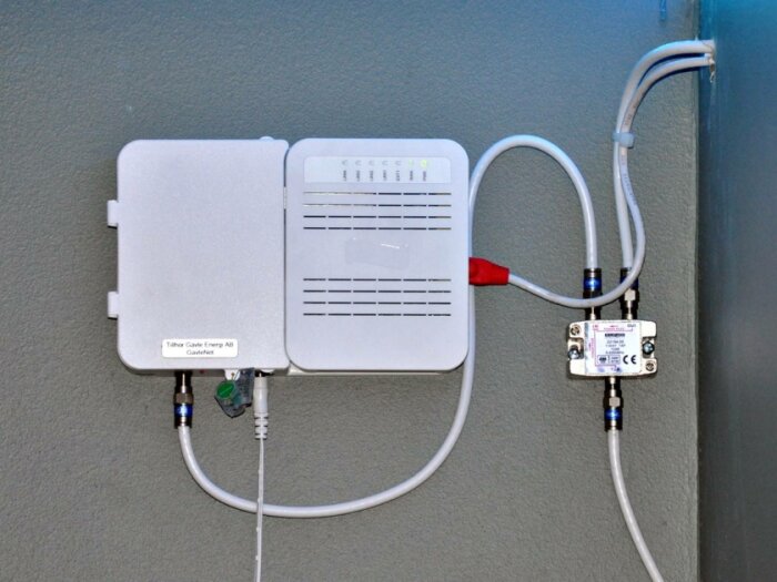 En CATV-modul monterad på en vägg, med fiberindata och utgående kabel-tv-anslutningar samt tillhörande kablage och splitter.