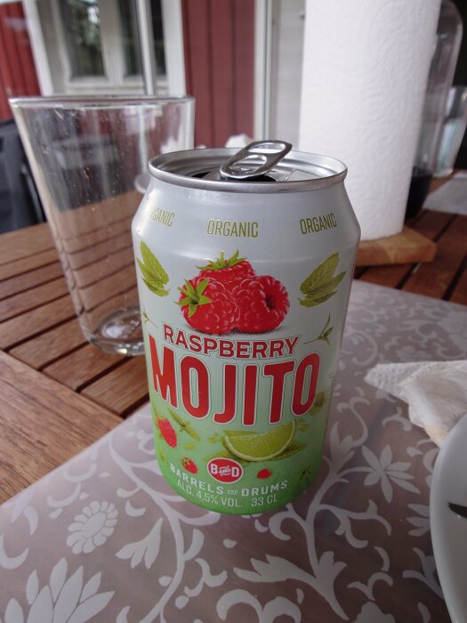 Burk med "Raspberry Mojito" stående på ett bord, i bakgrunden syns ett glas och en hushållspappersrulle.