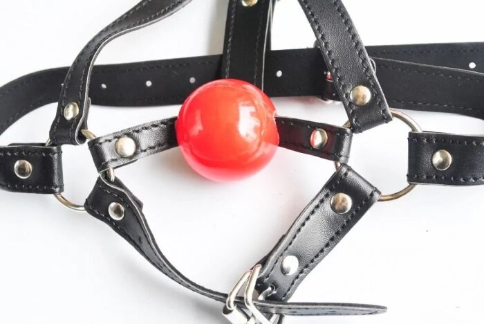 Svart lädersele med en röd boll, troligen ett gag för bondage eller rollspel.