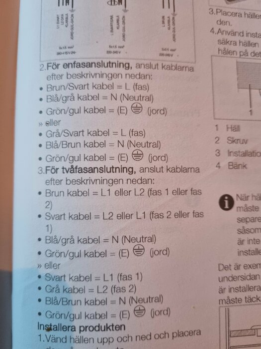 Närbild av en installationsmanual med instruktioner för anslutning av elkablar, inklusive färgkodning för enfas- och tvåfasanslutningar.