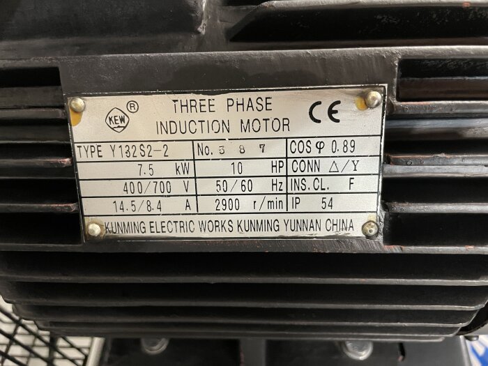 Typplåt på en trefas induktionsmotor med specifikationer som 7.5 kW, 10 HP, frekvens 50/60 Hz, märkspänning 400/700 V, från Kunming Electric Works.