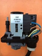 Tryckregulator XMP A1282142 12 bar med synliga elektriska ledningar mot en orange bakgrund.