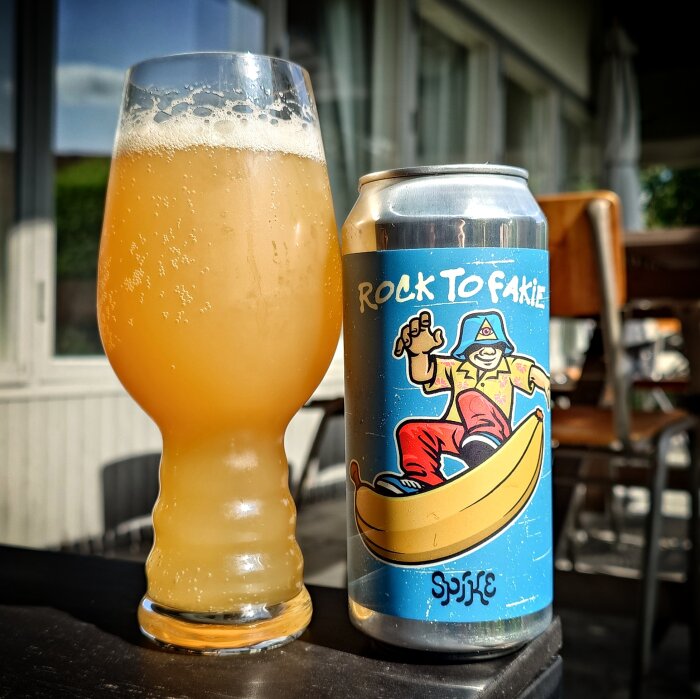 Ett glas med Spike Brewery NEIPA och en ölburk med etikett som visar en skateboardåkare på en banan, text: "Rock To Fakie".