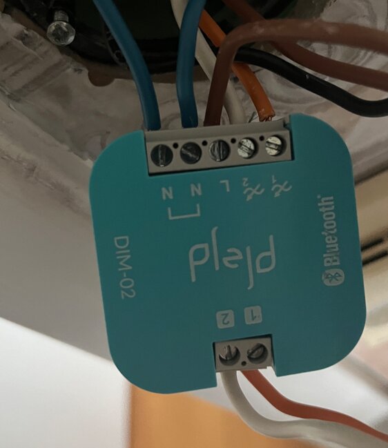 DIM-02 dimmer with connected electrical wires, including a black phase wire and a blue neutral wire, mounted in an electrical box.