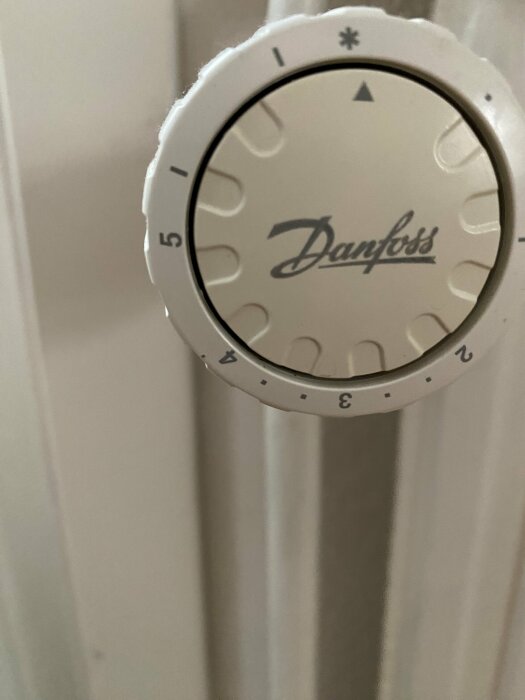 En termostat från Danfoss inställd på nivå två syns på bilden, med en vit bakgrund.