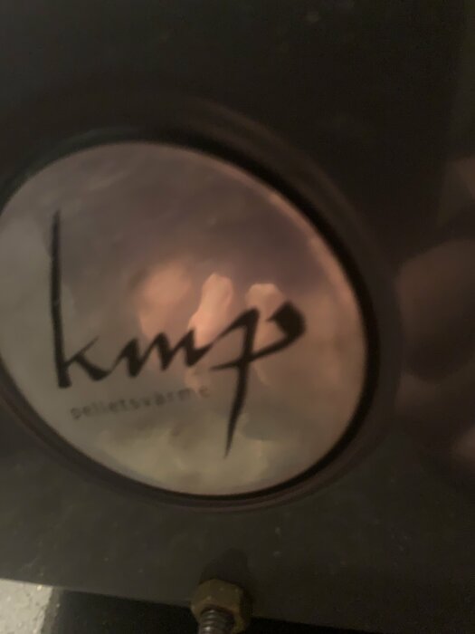 Närbild på en pelletsbrännare med logotypen "kmp".