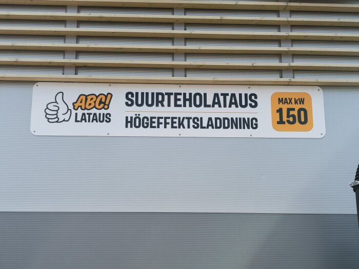 Skylt med texten "ABC! Lataus Suurteholataus Högeffektsladdning Max kW 150" som visar en laddstation med hög effekt för elbilar.