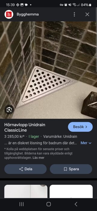 Triangulär hörnbrunn av märket Unidrain ClassicLine, installerad i ett duschhörn med mörka kakelplattor.