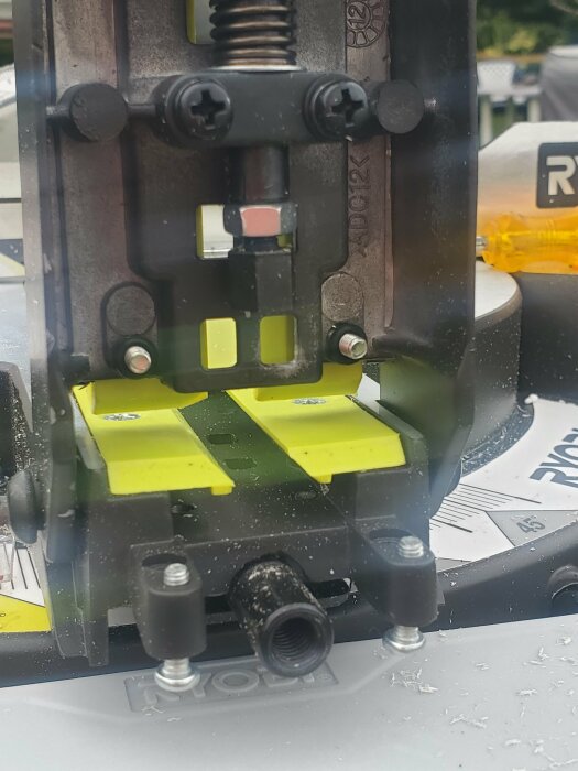 Närbild på en Ryobi gersåg som visar en del av sågen där en arm verkar saknas eller inte är ordentligt fastsatt i ett gängat hål.