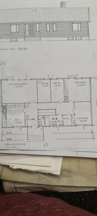 Byggnadsritning visar en våningsplan med vardagsrum, kök, WC, badrum och flera sovrum, inklusive två små sovrum om 7,4 och 7,8 kvm.