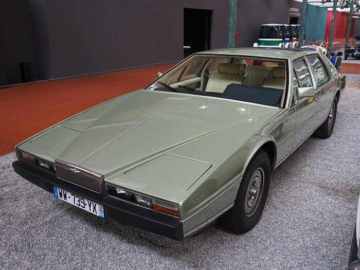 En grön vintagebil parkerad inomhus, fotograferad framifrån. Bilen är en DeLorean med en karakteristisk fyrkantig design och fransk registreringsskylt.