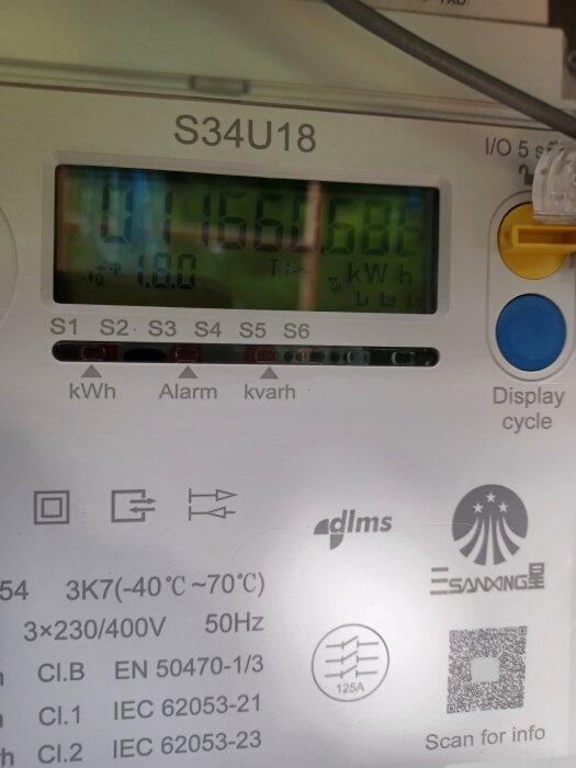 Bilden visar en energimätare av modellen S34U18 med en digital display som visar energiförbrukningen i kilowattimmar och andra tekniska specifikationer.