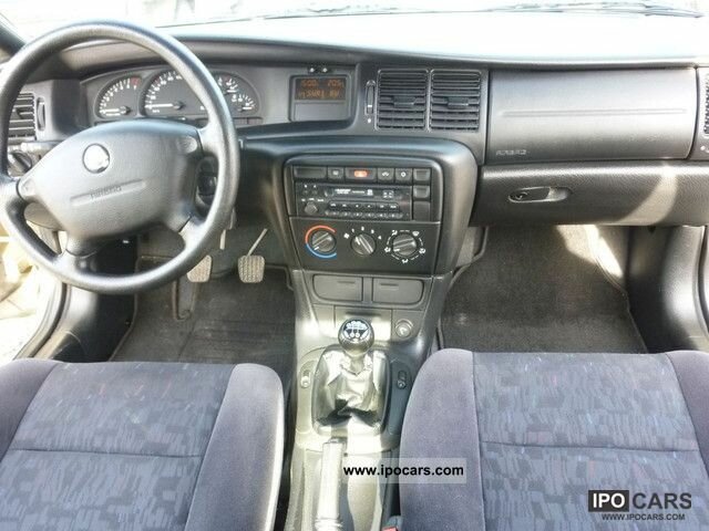 Interiör av SAAB 9-3 från 1998, med instrumentpanel, mittkonsol och framsäten visade. En bild från ipocars.com.