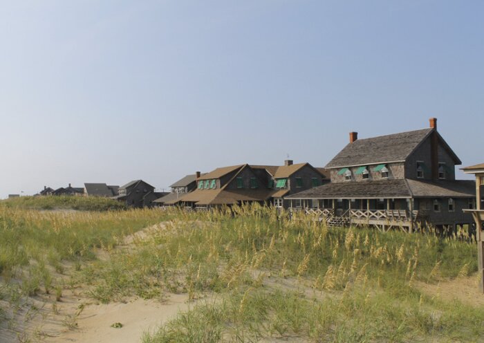 Omgivande sanddyner och flera historiska träbyggnader vid kusten i Nags Head, North Carolina, USA.