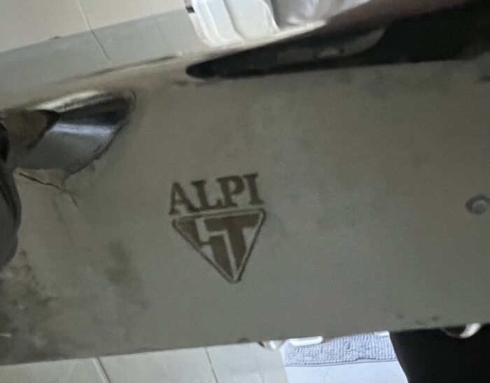 Blandare med ALPI-logotyp ingraverat, delvis reflekterande metallisk yta.