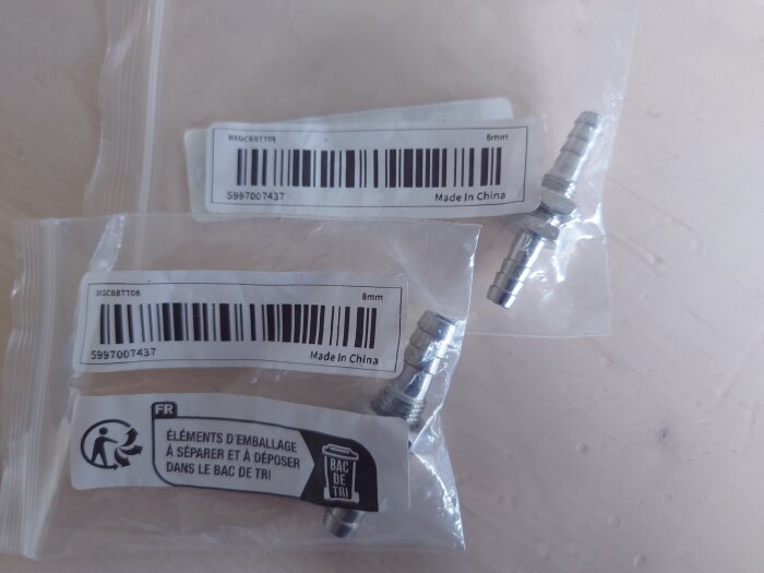 Två genomföringar i plastpåsar med etiketter som visar "Made in China" och "8 mm" på ett bord.