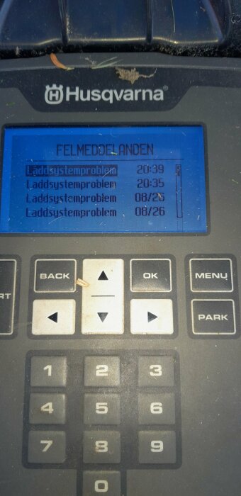 Skärm med felmeddelanden om laddsystemproblem på en Husqvarna-robotgräsklippare, visande flera tillfällen av laddsystemfel.