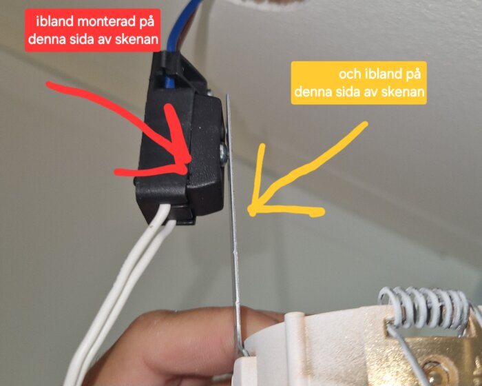 Svart kopplingsbox med buntband för halogenspottar, monterad olika sidor av metallskena enligt bildanvisningar med röd och gul pil markerade.