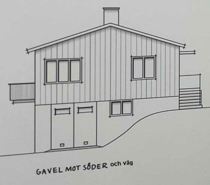 Ritning av ett sutteränghus med två fönster på ovanvåningen och två garageportar på undervåningen. Text: "Gavel mot söder och väg".