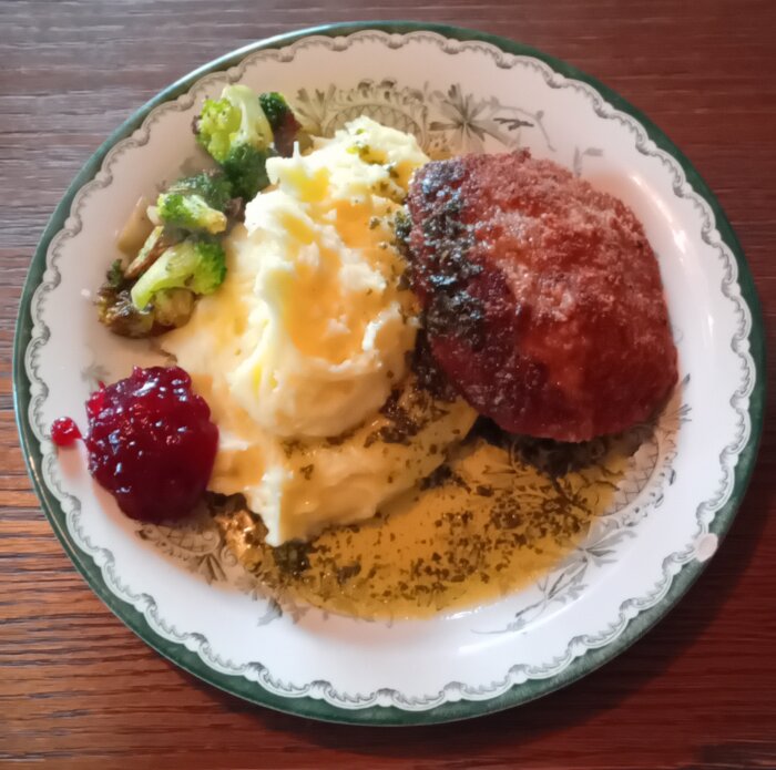 En tallrik med Wallenbergare, potatismos, persiljesmör, broccoli och en klick lingonsylt.