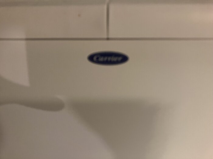 Bild på värmeelement i tvättstuga med märket Carrier synligt på en etikett.