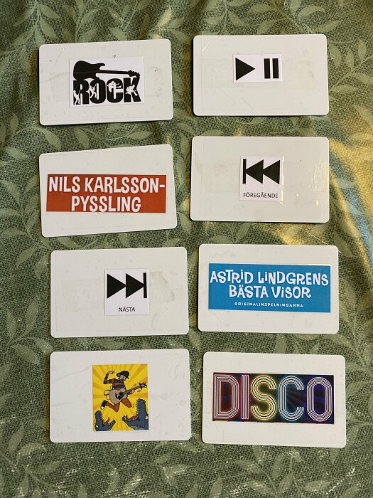 Sex NFC-taggar med olika etiketter och grafik, inklusive "ROCK", "NILS KARLSSON-PYSSLING", "ASTRID LINDGRENS BÄSTA VISOR", "DISCO", samt symboler för spelkontroller.