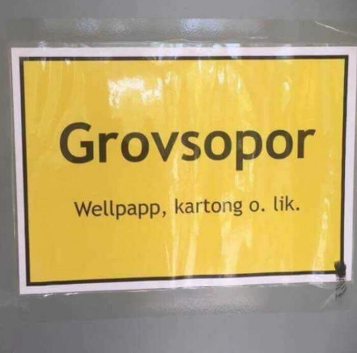 Skylt med texten "Grovssopor: Wellpapp, kartong o. lik." på gul bakgrund.