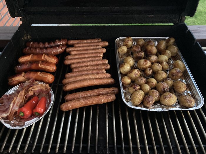 Korvar, bacon, paprikor och potatisar som grillas på en grill efter en dartkväll.