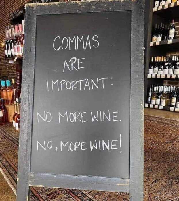 Svart tavla med texten "Commas are important: No more wine. No, more wine!" i en vinbutik.