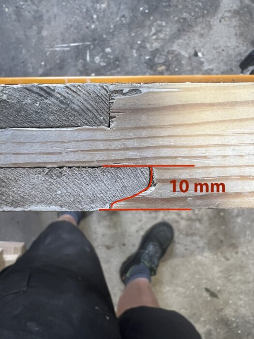 Närbild av träbitar med en kontraprofilfog markerad med en röd linje och mätning 10 mm.